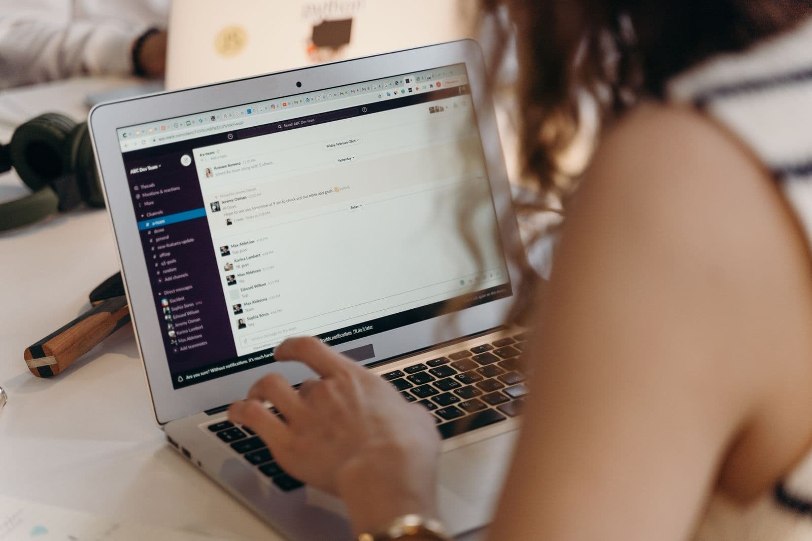 A woman working through her messages on a laptop