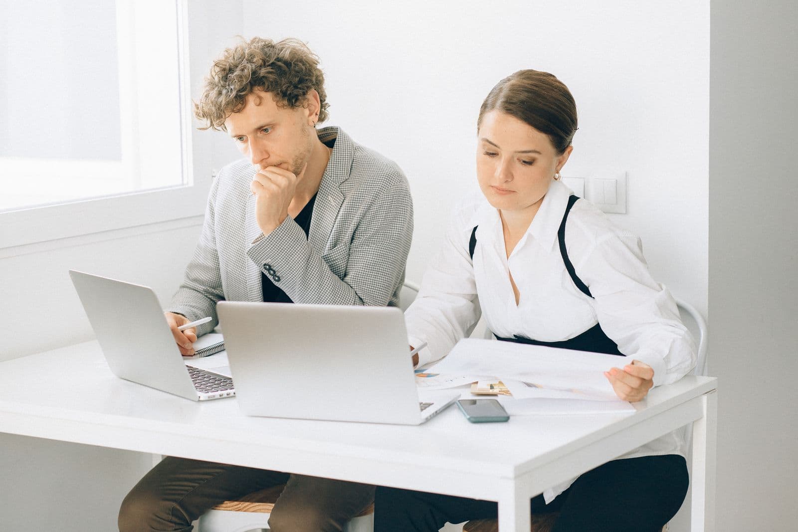 Two colleagues reviewing their existing setup together at a laptop